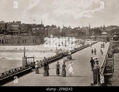 Eine Ansicht des Bournemouth Pier aus dem späten 19. Jahrhundert, ein gusseisernes Bauwerk aus dem Jahr 1880. Bevor der Küstenort 1810 von Lewis Tregonwell gegründet wurde, war das Gebiet eine verlassene dorset-Heide, die gelegentlich von Fischern und Schmugglern besucht wurde. Ursprünglich als Kurort vermarktet, erhielt die Stadt einen Schub, als sie 1841 in Augustus Granvilles Buch The Spas of England erschien. Bournemouth's Wachstum beschleunigte sich mit der Ankunft der Eisenbahn, und es wurde eine Stadt im Jahr 1870. Stockfoto