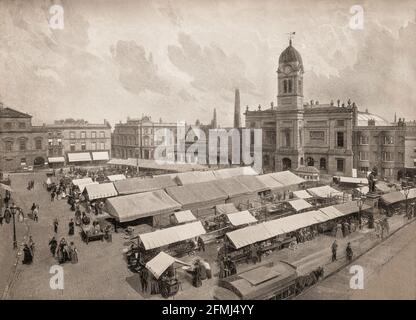 Ein Blick aus dem späten 19. Jahrhundert auf den Marktplatz in Derby, einer Stadt, die am Ufer des Flusses Derwent im Süden von Derbyshire liegt, von der sie traditionell die Grafschaftsstadt war. Mit Blick auf den Platz befindet sich die Guildhall, die von Richard Jackson im klassischen Stil entworfen und 1730 fertiggestellt wurde. Die von John Whitehurst entworfene Turmuhr wurde Mitte des 18. Jahrhunderts auf der Vorderseite des Gebäudes installiert. Stockfoto