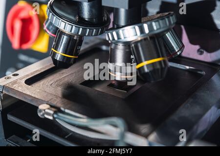 Modernes professionelles Mikroskop mit leistungsstarken Objektiven, die auf dem Tisch in platziert sind Modern ausgestattetes Labor Stockfoto