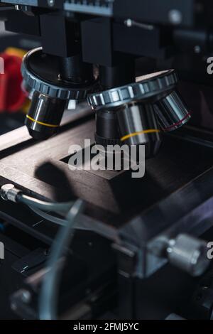 Modernes professionelles Mikroskop mit leistungsstarken Objektiven, die auf dem Tisch in platziert sind Modern ausgestattetes Labor Stockfoto