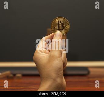 Abstrakte Hand mit Bitcoin- und Euro-Münzen. Das Konzept der digitalen Währung für das weltweite Bankwesen und Unternehmensinvestitionen. Stockfoto