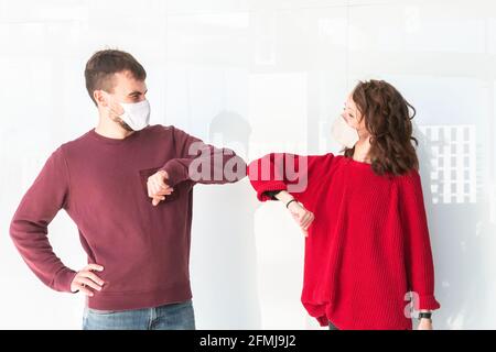 Begrüßung mit Ellenbogenstoß auf der Straße. Zwei Personen grüßen Ellenbogen und stoßen. Kollegen machen im Büro Ellenbogen-Beulen. Neuer Stil der Begrüßung während des Coronavirus Stockfoto