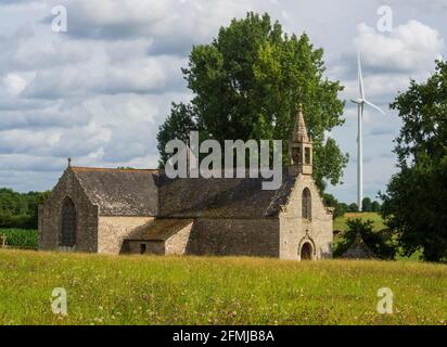 Im Vordergrund die Sainte-Anne Kapelle, dahinter eine Windturbine, Buléon, Morbihan, Bretagne, Frankreich. Stockfoto