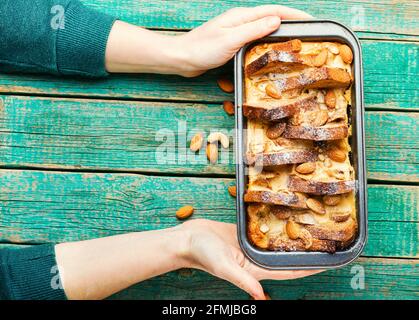 Dessert mit Toastbrot, Quark, Banane und Nüssen. Französisches Frühstück in Händen Stockfoto