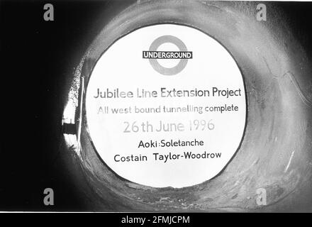 35 METER UNTER DER ERDE. BEI DER DURCHBRUCHZEREMONIE FÜR DIE JUBILEE-STRECKENVERLÄNGERUNG STEHT EINE TUNNELBOHRMASCHINE KURZ VOR DEM ABSTURZ DURCH EINE NEU GEBAUTE BREEZEBLOCK-WAND Stockfoto