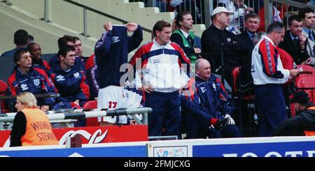 England's Teddy Sheringham in England / Bulgarien 1998 about to Come On holt sein Top-off als Trainer Glenn Hoddle Und Ray Clemence schauen sich das Spiel an Stockfoto