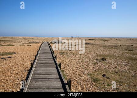 Holzbrett zu Fuß über den riesigen Kiesstrand in Dungeness kent Stockfoto