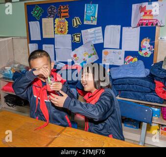 Die Schüler lernen, Schleim zum ersten Mal zu machen und Führen Sie das Experiment zum Ausbruch eines Vulkans durch Stockfoto