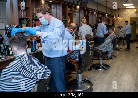 Athlone, Westmeath, Irland, 10. Mai 2021. Barber Bobs, ein lokaler Barber, eröffnet wieder mit Online-Buchungen gemäß den Covid 19-Beschränkungen in Irland. Die Kunden genießen es, einen lang erwarteten Haarschnitt zu bekommen, und die Mitarbeiter sind glücklich, wieder bei der Arbeit zu sein. Quelle: Eoin Healy/Alamy Live News Stockfoto