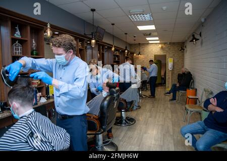 Athlone, Westmeath, Irland, 10. Mai 2021. Barber Bobs, ein lokaler Barber, eröffnet wieder mit Online-Buchungen gemäß den Covid 19-Beschränkungen in Irland. Die Kunden genießen es, einen lang erwarteten Haarschnitt zu bekommen, und die Mitarbeiter sind glücklich, wieder bei der Arbeit zu sein. Quelle: Eoin Healy/Alamy Live News Stockfoto