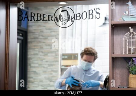 Athlone, Westmeath, Irland, 10. Mai 2021. Barber Bobs, ein lokaler Barber, eröffnet wieder mit Online-Buchungen gemäß den Covid 19-Beschränkungen in Irland. Die Kunden genießen es, einen lang erwarteten Haarschnitt zu bekommen, und die Mitarbeiter sind glücklich, wieder bei der Arbeit zu sein. Quelle: Eoin Healy/Alamy Live News Stockfoto