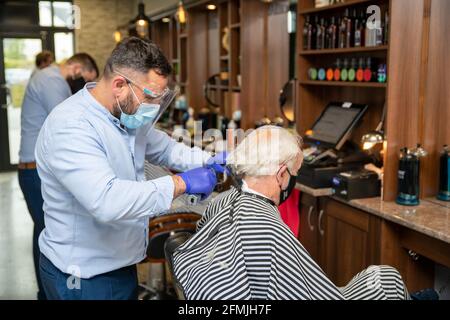 Athlone, Westmeath, Irland, 10. Mai 2021. Barber Bobs, ein lokaler Barber, eröffnet wieder mit Online-Buchungen gemäß den Covid 19-Beschränkungen in Irland. Die Kunden genießen es, einen lang erwarteten Haarschnitt zu bekommen, und die Mitarbeiter sind glücklich, wieder bei der Arbeit zu sein. Quelle: Eoin Healy/Alamy Live News Stockfoto