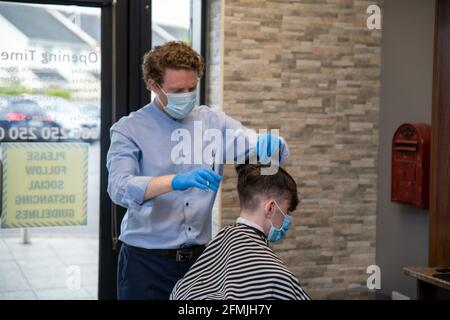 Athlone, Westmeath, Irland, 10. Mai 2021. Barber Bobs, ein lokaler Barber, eröffnet wieder mit Online-Buchungen gemäß den Covid 19-Beschränkungen in Irland. Die Kunden genießen es, einen lang erwarteten Haarschnitt zu bekommen, und die Mitarbeiter sind glücklich, wieder bei der Arbeit zu sein. Quelle: Eoin Healy/Alamy Live News Stockfoto