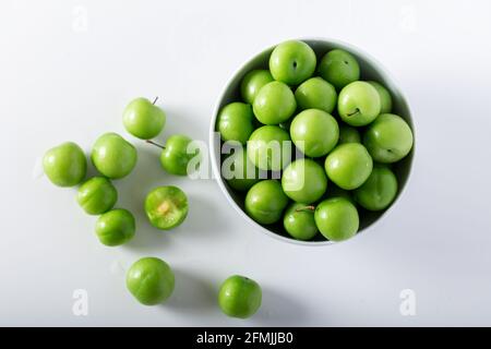 Frische grüne Pflaumen in einer weißen Schüssel. Draufsicht. Stockfoto
