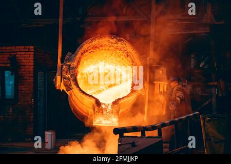 Geschmolzenes Metall in einem großen Schöpfkeller. Eisenguss in Metallurgie Gießerei, Schwerindustrie. Stockfoto