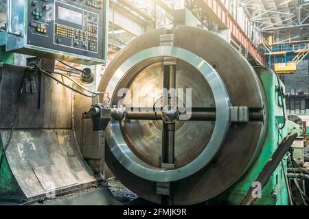 Drehmaschine in der Werkshalle, Bohren des Teils mit Fräswerkzeug. Metallbearbeitungsmaschine schleift Rohr Metallprodukt. Stockfoto