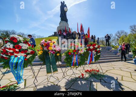 9. Mai 2021, Berlin, am sowjetischen Kriegsdenkmal im Treptower Park (Treptower Ehrenmal), einem Denkmal und gleichzeitig einem Militärfriedhof, gedenken zahlreiche Russen und Deutsch-Russen mit vielen bunten Fahnen des 76. Siegestages am Ende des Zweiten Weltkriegs. Das Denkmal wurde 1949 auf Anweisung der sowjetischen Militärverwaltung in Deutschland errichtet, um die im Zweiten Weltkrieg verstorbenen Soldaten der Roten Armee zu ehren Über 7000 der in den Schlacht um Berlin verstorbenen Soldaten sind hier begraben. Im Bild: gedenkkranz vor der kolossalen Statue mit Kind und Bruch Stockfoto