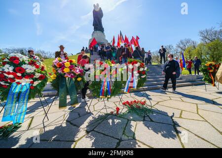 9. Mai 2021, Berlin, am sowjetischen Kriegsdenkmal im Treptower Park (Treptower Ehrenmal), einem Denkmal und gleichzeitig einem Militärfriedhof, gedenken zahlreiche Russen und Deutsch-Russen mit vielen bunten Fahnen des 76. Siegestages am Ende des Zweiten Weltkriegs. Das Denkmal wurde 1949 auf Anweisung der sowjetischen Militärverwaltung in Deutschland errichtet, um die im Zweiten Weltkrieg verstorbenen Soldaten der Roten Armee zu ehren Über 7000 der in den Schlacht um Berlin verstorbenen Soldaten sind hier begraben. Im Bild: gedenkkranz vor der kolossalen Statue mit Kind und Bruch Stockfoto