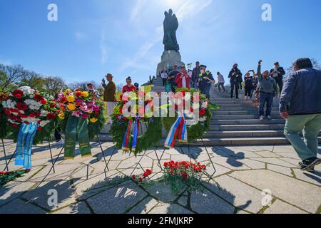 9. Mai 2021, Berlin, am sowjetischen Kriegsdenkmal im Treptower Park (Treptower Ehrenmal), einem Denkmal und gleichzeitig einem Militärfriedhof, gedenken zahlreiche Russen und Deutsch-Russen mit vielen bunten Fahnen des 76. Siegestages am Ende des Zweiten Weltkriegs. Das Denkmal wurde 1949 auf Anweisung der sowjetischen Militärverwaltung in Deutschland errichtet, um die im Zweiten Weltkrieg verstorbenen Soldaten der Roten Armee zu ehren Über 7000 der in den Schlacht um Berlin verstorbenen Soldaten sind hier begraben. Im Bild: gedenkkranz vor der kolossalen Statue mit Kind und Bruch Stockfoto