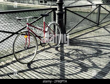 Vintage rotes Fahrrad auf Pont des Arts in Paris, Frankreich Stockfoto