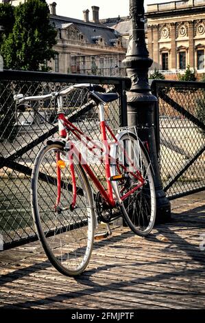 Vintage rotes Fahrrad auf Pont des Arts in Paris, Frankreich Stockfoto