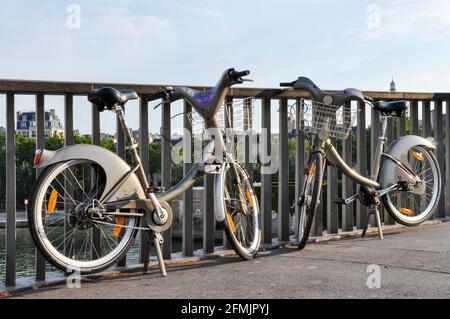 PARIS, FRANKREICH - CA. AUGUST 2009: Zwei Velib' auf einer Brücke auf der seine. Velib' ist ein öffentliches Fahrradverleihsystem Stockfoto