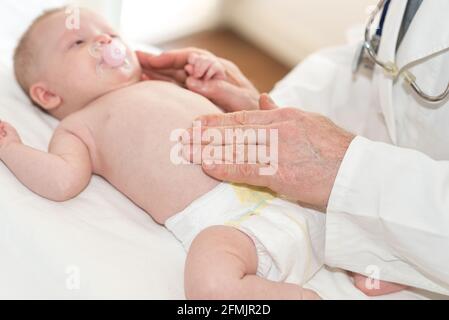 Arzt Kinderarzt untersucht Babybauch in der Klinik Stockfoto