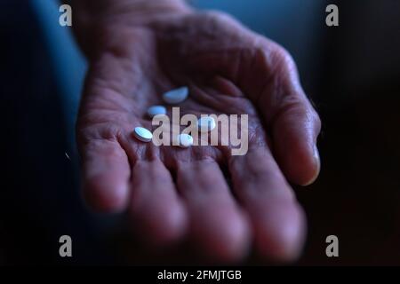 Pillen in der Hand des alten mannes. Sozialhilfe, gibt Medizin. Selektiver Fokus Stockfoto