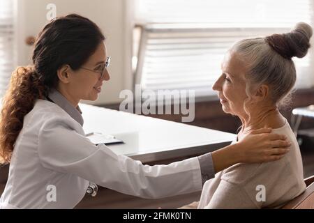 Frau gp sprechen mit reifen Dame Hand auf Schulter halten Stockfoto
