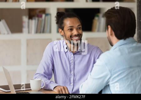 Nahaufnahme lächelnder afroamerikanischer Mann mit Kollegen, die zusammenarbeiten Stockfoto