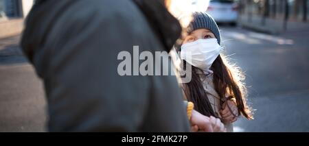 Unverkennbare Mutter mit kleiner Tochter, die draußen auf der Straße läuft, Coronavirus-Konzept. Stockfoto