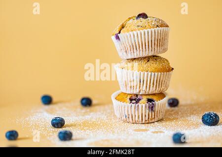 Drei Muffins, geheftet mit blauem und orangefarbenem Hintergrund Stockfoto