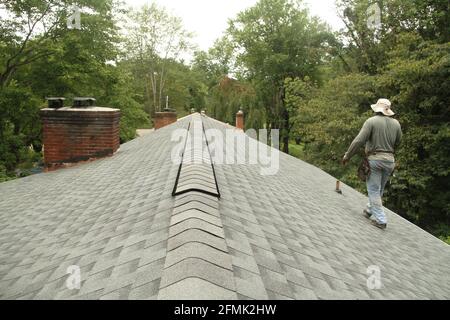 Arbeiter auf dem Dach eines Hauses. Dachfirst. Stockfoto