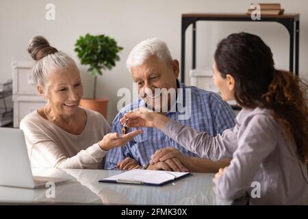 Überglücklich Senior Ehepartner immobilienkäufer erhalten Schlüssel in realtor Büro Stockfoto