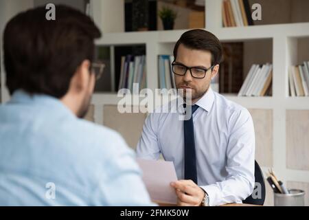 Serious Geschäftsmann hr Manager lesen Lebenslauf, führt Vorstellungsgespräch Stockfoto