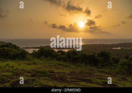 Sonnenuntergang über dem Horizont. Schöne Aussicht auf die Landschaft und das Meer in der Ferne. Lebendige, weiche Farben und magisches Licht. Stockfoto