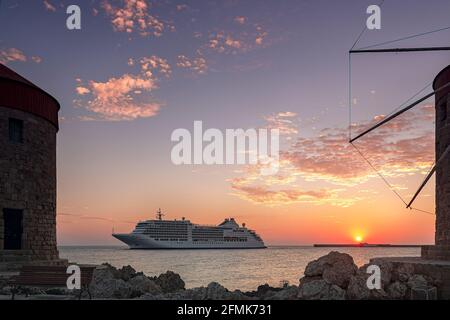 RHODOS, GRIECHENLAND - 06. OKTOBER 2018: Das Luxuskreuzfahrtschiff der silbernen Muse macht sich bereit, bei Sonnenaufgang am Hafen von rhodos anzudocken. Stockfoto