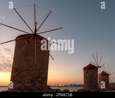 Die Windmühlen in der Nähe der Altstadt von Rhodos, mandraki, Hafen bei Sonnenaufgang. Stockfoto