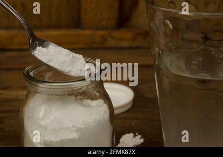 Natriumbicarbonat und Glas Wasser, Lösung mit mehreren Verwendungen. Weißes Pulver wie Talkum Stockfoto