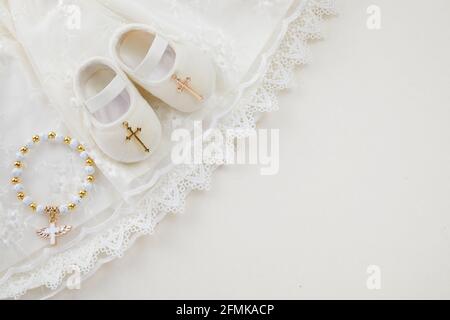 Taufe Hintergrund mit Taufe Baby Kleid, Schuhe, und Kreuz auf pastellfarbenem Hintergrund Stockfoto