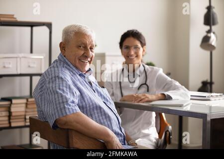 Junge Dame Therapeut konsultieren alten Mann Patient in der Klinik Büro Stockfoto
