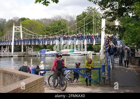 Auf der Fußgängerbrücke bei Teddington Lock versammeln sich Menschen, um einen drei bis vier Meter langen Minke-Wal zu erspähen, der am Sonntag freigelassen wurde, nachdem er auf Richmond lockÕs Bootswalzen stecken geblieben war, aber in der Themse geblieben ist. Bilddatum: Montag, 10. Mai 2021. Stockfoto