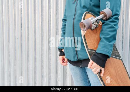 Gesichtsloses Mädchen, das ihr Skateboard hält. Platz für Text kopieren. Konzept des nachhaltigen Transports und einer gesunden Lebensweise. Stockfoto