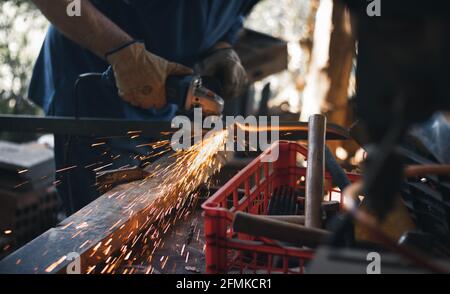 Arbeiten in einem Stück Eisen mit einer Schleifmaschine Stockfoto