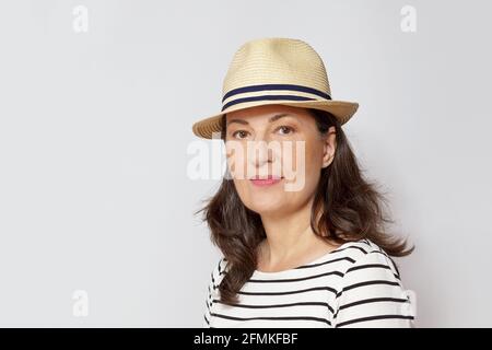 Portrait oder Headshot einer sehr glücklichen Frau mittleren Alters mit langen braunen Haaren, weißem Hintergrund. Stockfoto