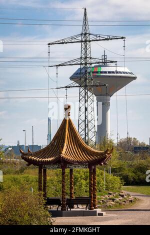 Chinesischer Drachenpavillon im Neuland-Park, im Hintergrund der Wasserturm der Energieversorgung Leverkusen und eine hohe Stockfoto