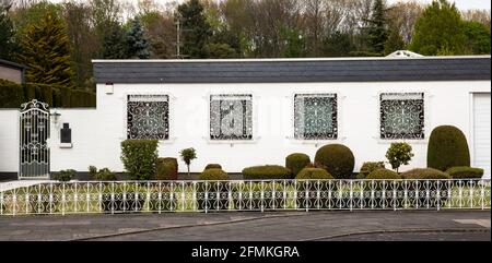 Bungalow mit schmiedeeisernen Fenstergittern und Zaun in Hürth, Nordrhein-Westfalen, Deutschland. Bungalow mit schmiedeeisernen Fenstergittern und Zaun Stockfoto