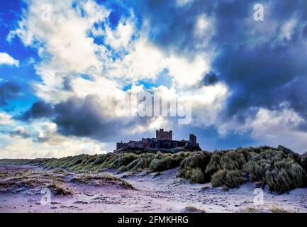 Über Bamburgh Castle, auf den Dünen von Bamburgh Village, Northumberland, England, erhebt sich ein großer Winterhimmel Stockfoto