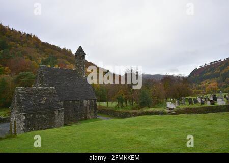 Herbstlandschaft mit Panoramablick auf St. Kevin's mittelalterliche Sandsteinkapelle in der Landschaft von Glendalough Valley County Wicklow, Irland. Stockfoto