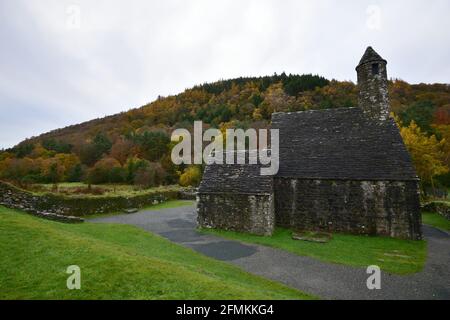 Herbstlandschaft mit Panoramablick auf St. Kevin's mittelalterliche Sandsteinkapelle in der Landschaft von Glendalough Valley County Wicklow, Irland. Stockfoto